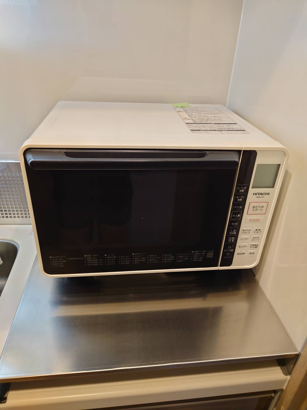 コンロカバーの上に載せた電子レンジ。奥の壁に寄せて置いてある