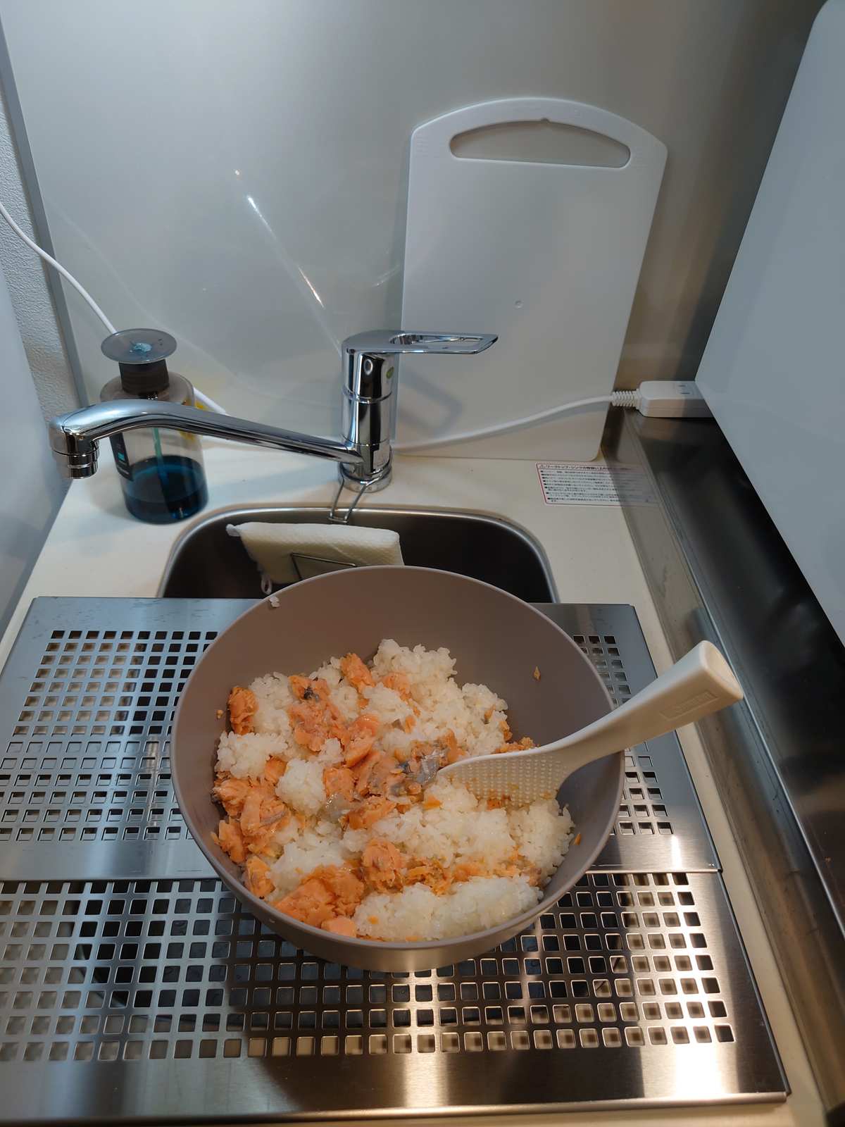 プレートの上で、鮭とご飯を混ぜているところ。奥の壁に立てかけてあるのが、置き場所のなかったまな板