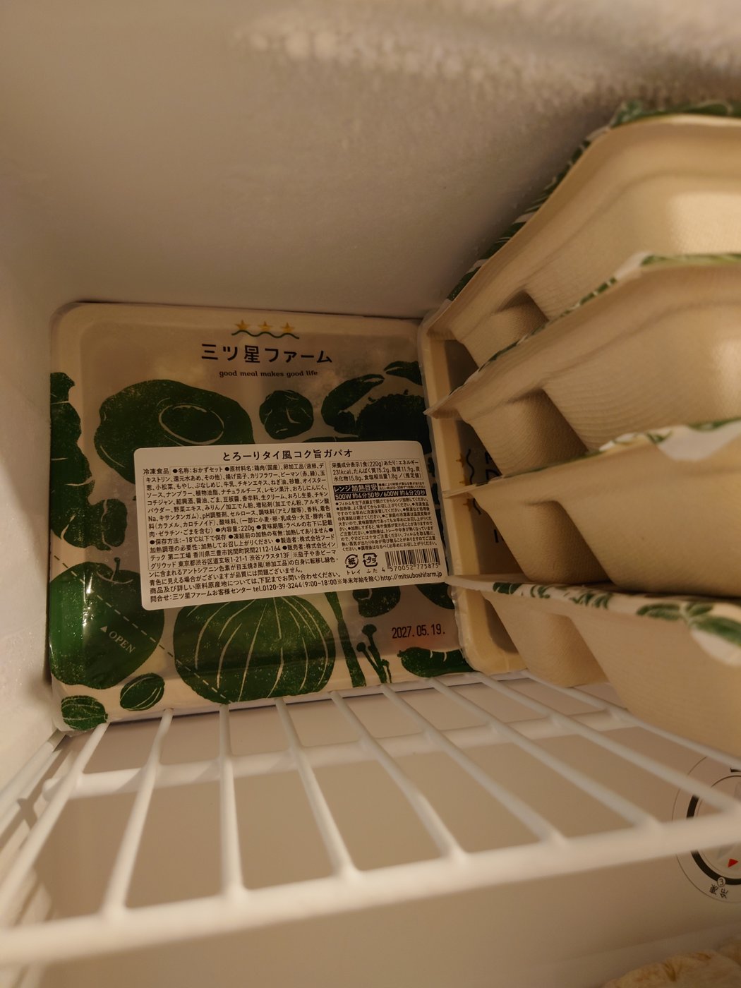 冷凍庫の中。トレイを同じ向きに寝かせて積み上げてあり、手前の1つはラベルが見えるように置かれている